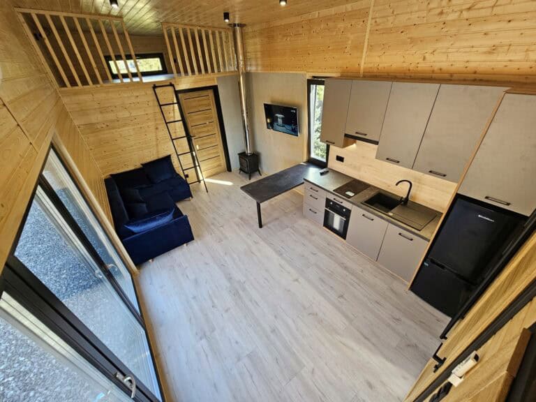 Wnętrze tiny house - drewniane wykończenie, aneks kuchenny z salonem